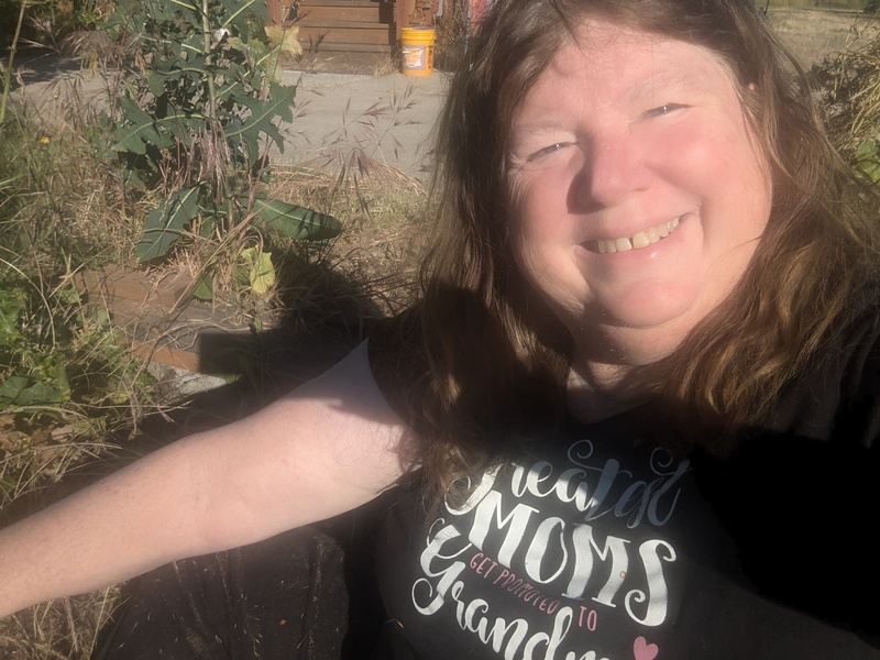 Lois pulling weeds in the sandbox.