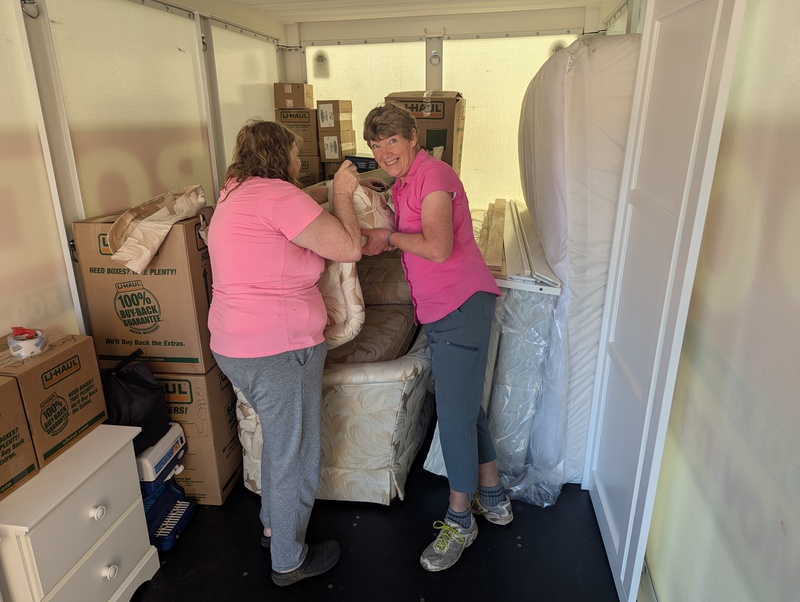 Lois and Laura loading a couch upside down.