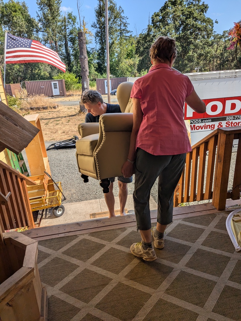 Joseph and Laura move a recliner.