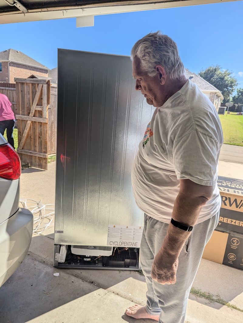 Don wheeling our new freezer into the garage.