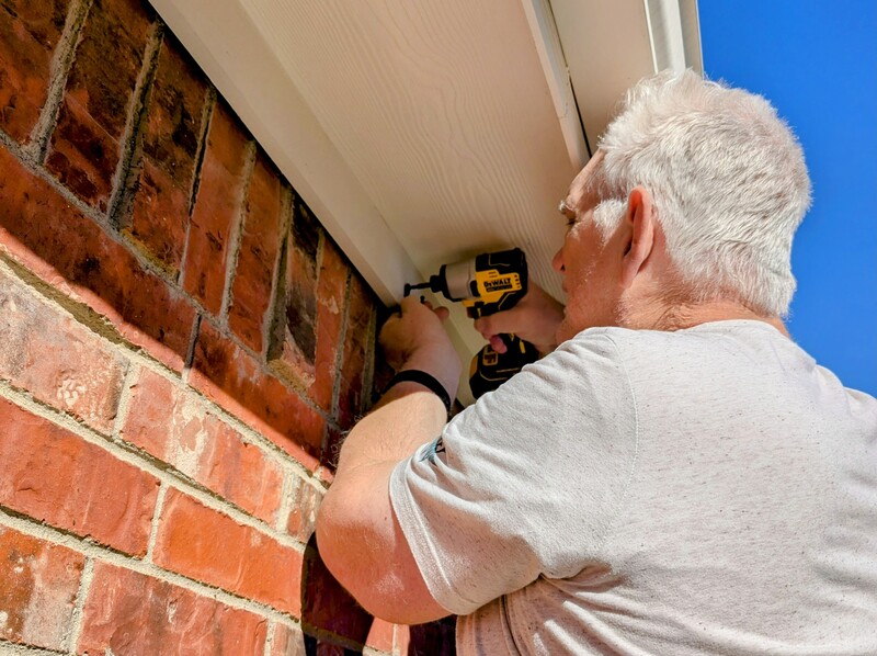 Don attaches hooks for Christmas lights.