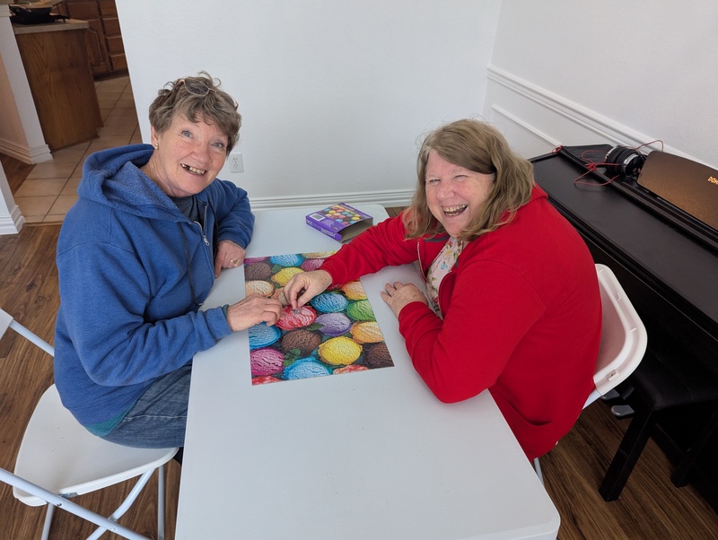 Laura and Lois finish a puzzle.