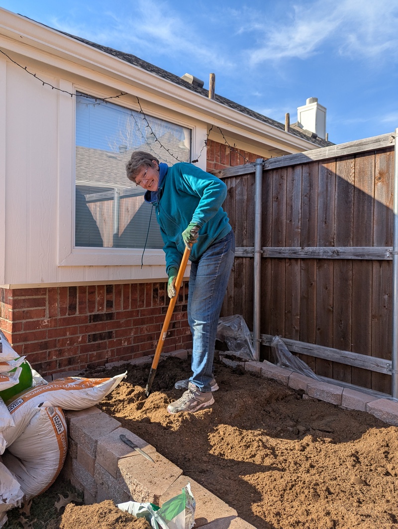 Laura turning over dirt.
