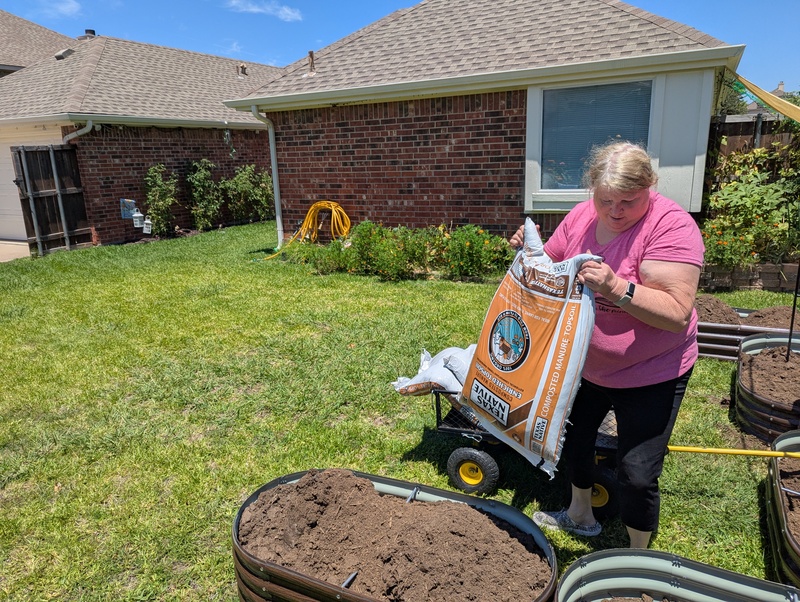 Lois moved the bags of dirt to the garden cells.