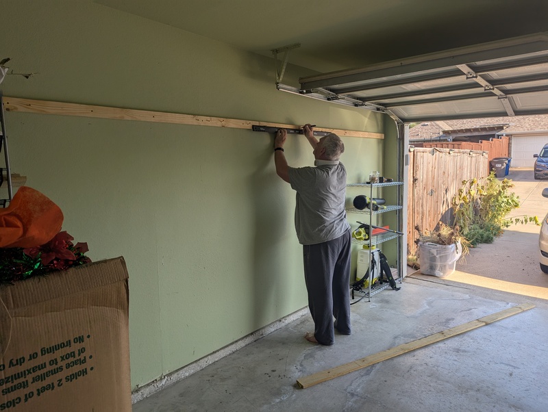 Don putting hooks for hanging tools in our garage.