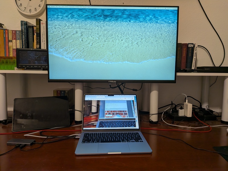 Don's tiny 15in laptop screen and his new 32in external monitor on its support arm.