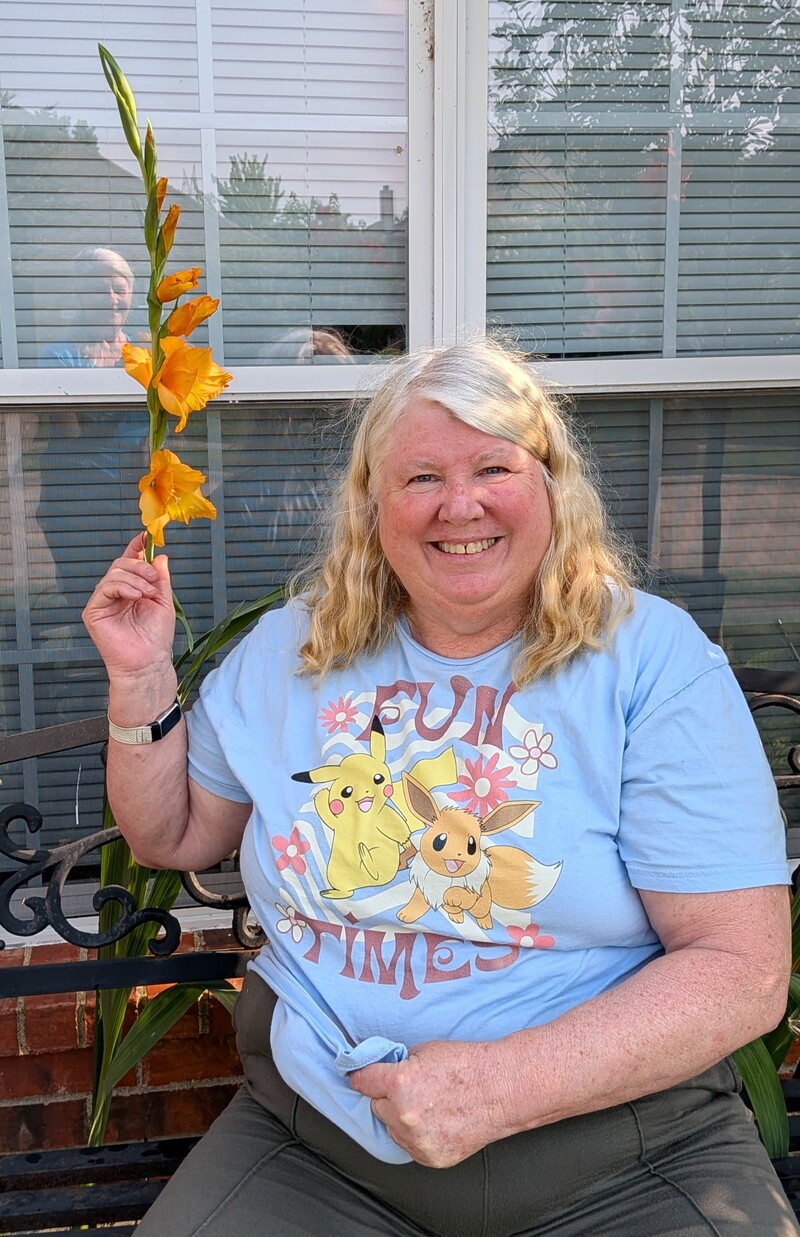 See how tall this orange gladiolus is. I also have a bunch of tomatoes in my shirt. 🤣