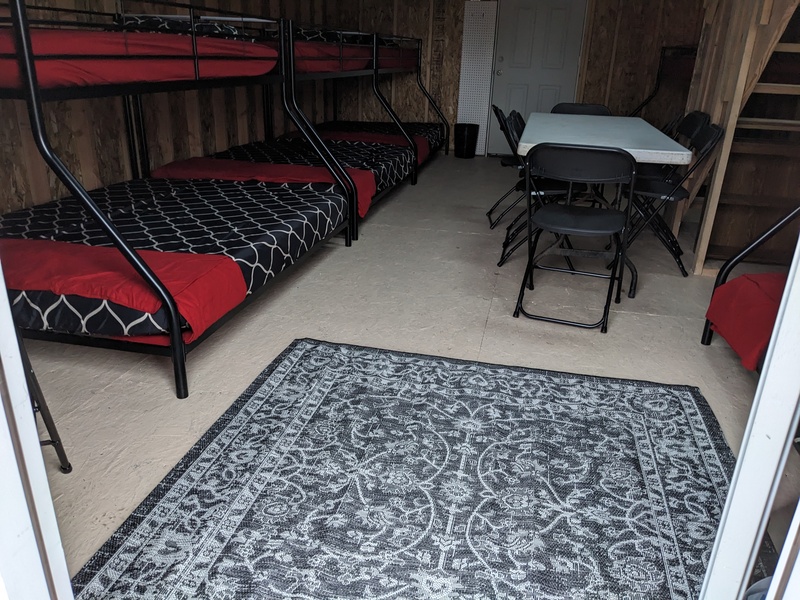 B2 entryway rug, table, chairs, and several bunk beds.