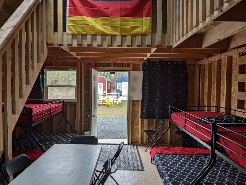 B2 entryway rug, table, chairs, and several bunk beds. Flag of Germany hangs inside honoring our German relatives.