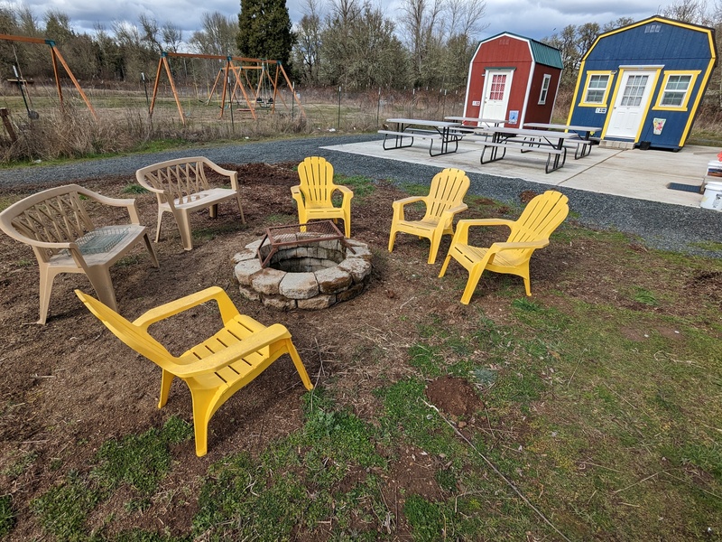Chairs around the Fire Pit. Nordic Plaza includes four bunkhouses and four picnic tables.